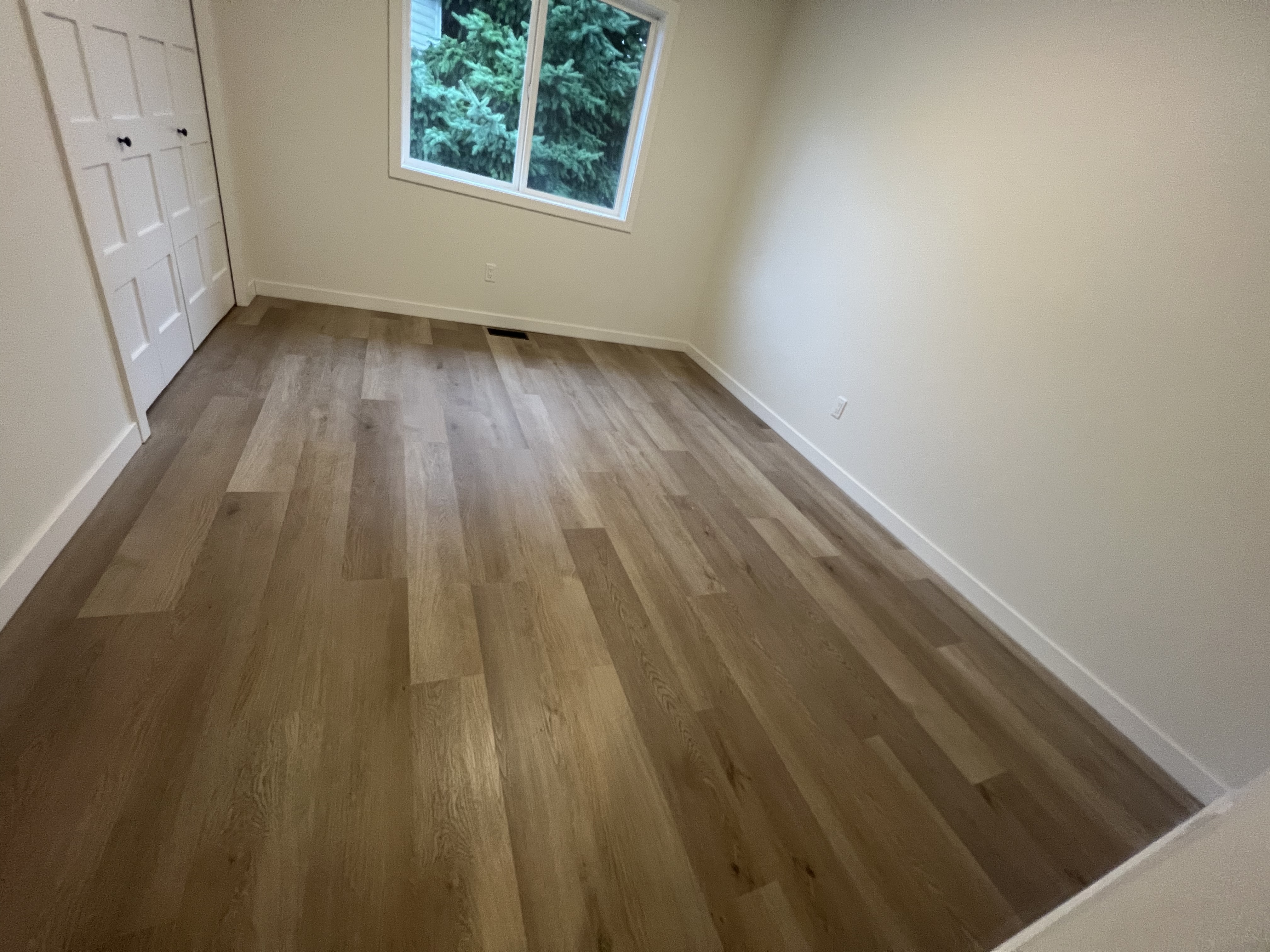 Finished room with new flooring, trim, window, and lighting